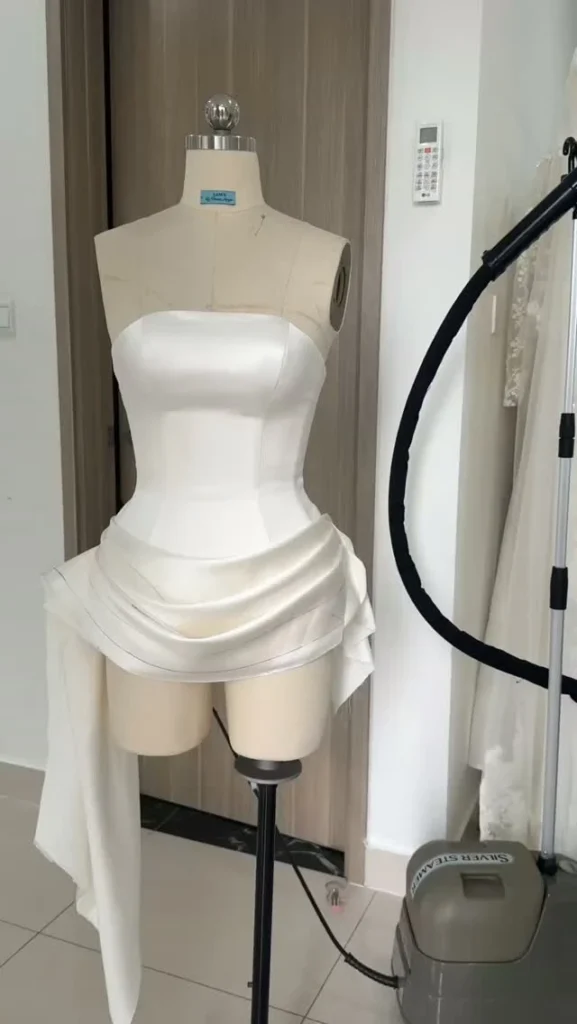 Váy after party lụa phom corset siết eo, chân váy xếp nếp với tà lệch bên hông