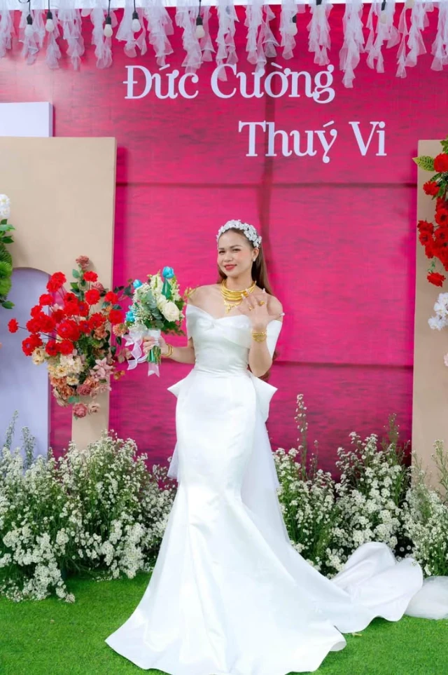 Dâu mỉm cười, cận phần vai ngang và thân váy satin ôm dáng