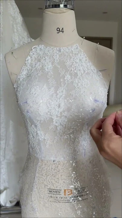 Thân váy cưới ren gân Pháp cổ yếm đang được đắp ren trên ma-nơ-canh tại studio LAM’S